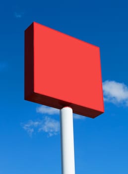 Red blank billboard on a sunny day with blue sky