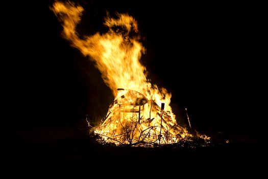 mountiain of debris burning with intensity in the night