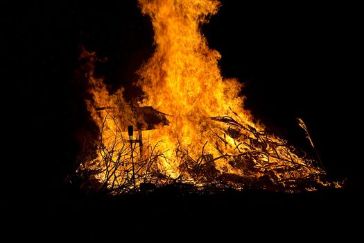 mountiain of debris burning with intensity in the night
