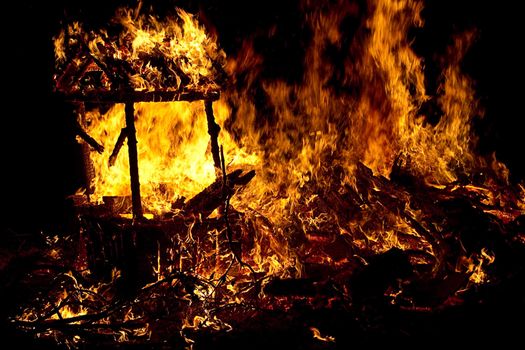 mountiain of debris burning with intensity in the night