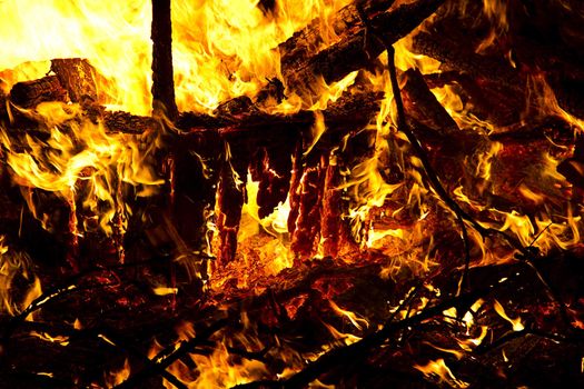 mountiain of debris burning with intensity in the night