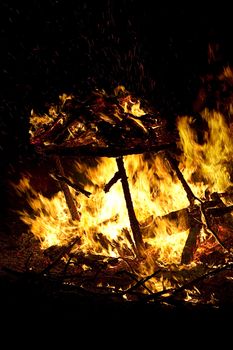 mountiain of debris burning with intensity in the night