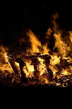 mountiain of debris burning with intensity in the night