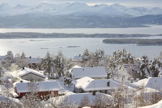 Snowy houses in a white winter landscape in western Norway.