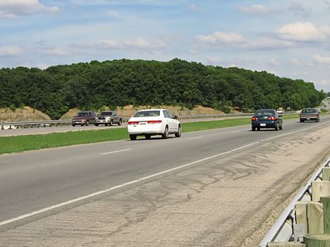 A photograph of automobiles traveling on a road.