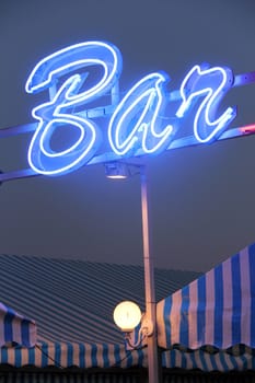 Bright blue advertisement light with the word BAR