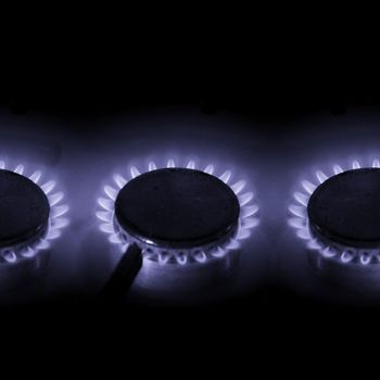 three hot burning gas cookers with blue power