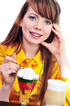 pretty longhaired blue-eyed girl enjoying cream and dessert in cafe 