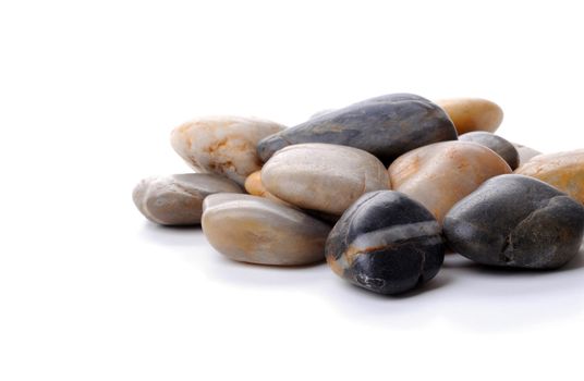 Pile of polished river rocks on a white background