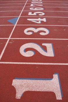 Red treadmill at the stadium with the numbering from one to nine.