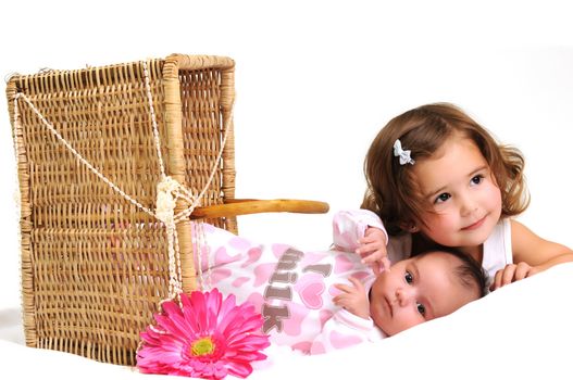 two sisters playing and smiling in a basket with pink flower