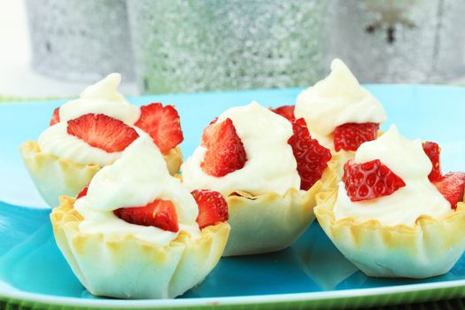 Cream cheese tarts with slices of strawberry.