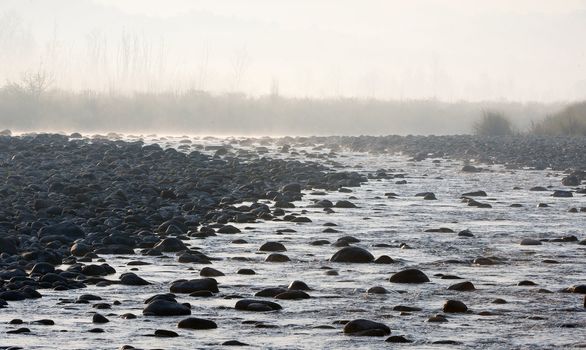 River flowing on rocks with mountains in the background, Jim Corbett National Park, Pauri Garhwal, Uttarakhand, India.