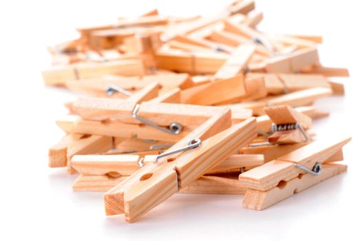 Pile of wooden clothespins on a white background.