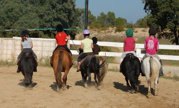 group of children horseback riding on their shetland ponies