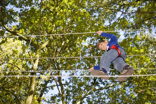 a boy climbing in adventure park