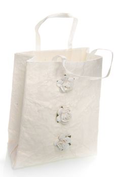 a handmade white bag with three little roses on a white background