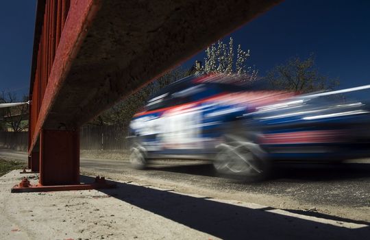 blurred rally car in motion on a bridge, construction in picture, photo taken in slovakia