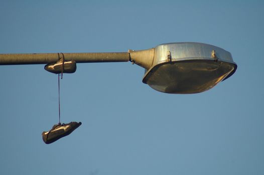 detail of street lamp and shoes hanging on it