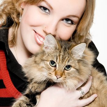 Studio portrait of a young blond curly woman holding a cute main coone kitten