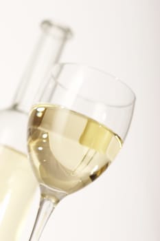 glass of white wine on the blurred bottle background