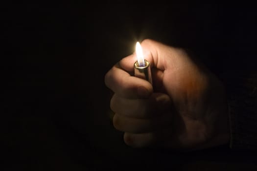 Hand with a lighter on a black background