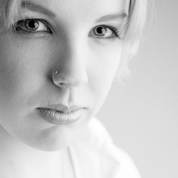 Studio portrait of a young blond curly woman looking confident