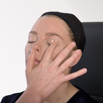 Studio image of make-up artist at work applying eye make-up