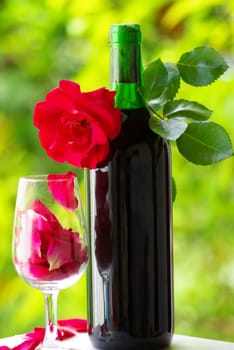 Petals of rose in a glass of red wine.