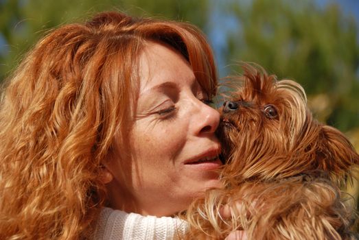 woman with red hair and her purebred yorkshire terrier