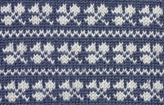 Knitted  white shamrock pattern on blue background