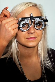 Young woman examining the eyesight in the optician's 