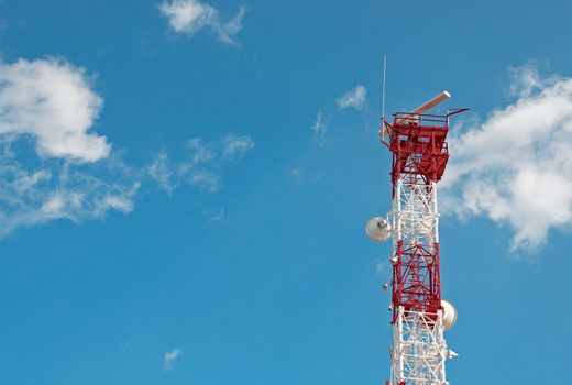 Tall telecomunication tower against blue sky background