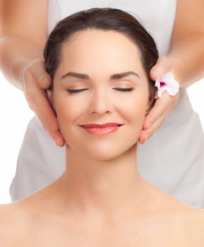 A portrait of a beautiful young woman getting a face massage