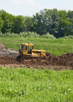 The old caterpillar tractor works in the fields