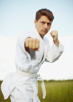 The young man is engaged in karate open-air