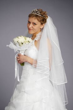 Formal portrait of beautiful bride on a gray background