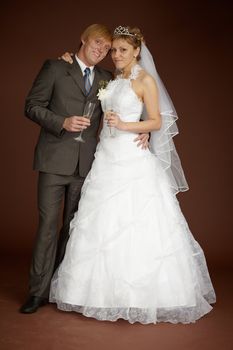 The bride and groom together on a brown background