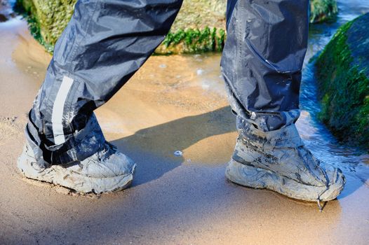 To walk of dirty shoes along a sandy sea coast