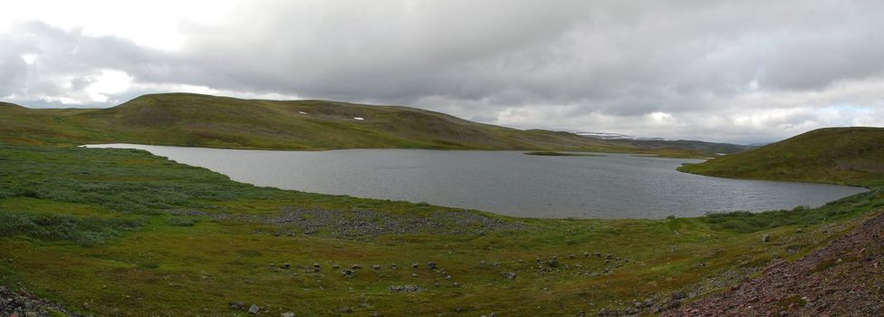 Wild lanscape of Finnmark in the border of Porsangen fjord, havy clouds are very close to nordic tundra 
