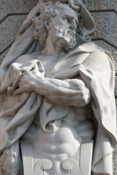 a sculptured man holding a towel with his hand