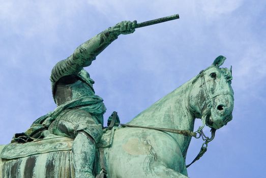 a statue of a leader riding on a horse pointing with a stick