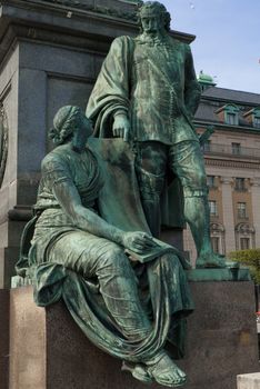 a statue of a man dictating a women to write something down in stockholm