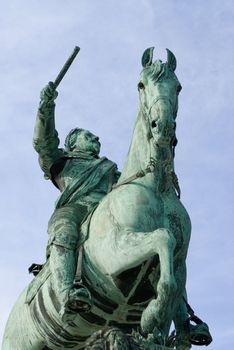 a statue of a leader riding on a horse pointing with a stick