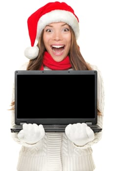 Christmas computer woman holding notebook excited wearing santa hat. Empty blank screen copy space for text. Beautiful young smiling female model isolated on white background.