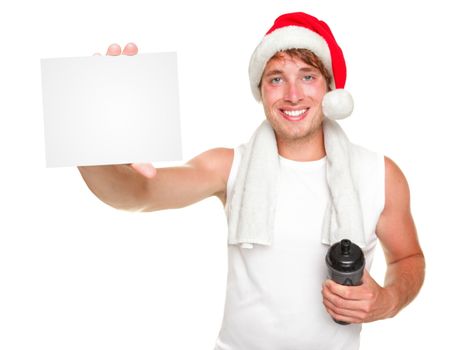 Christmas santa exercise man showing white gift / business card for holiday message. Fit young man wearing santa hat Isolated on white background.