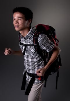 Asian man excited about hiking in the outdoors wearing backpack