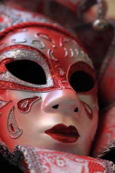 Closeup image of a red Venetian mask.