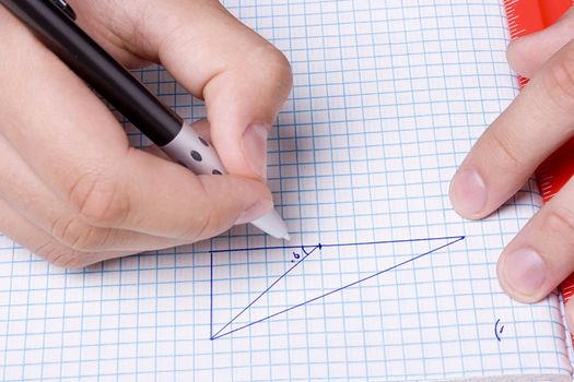 Student solving a mathematic problem using a pen and a ruler.