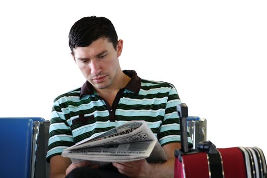 Man reading newspaper at the airport in the sitting